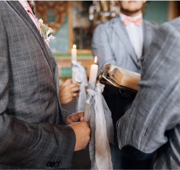 Elegant wedding ceremony with groomsmen holding candles and reading vows.