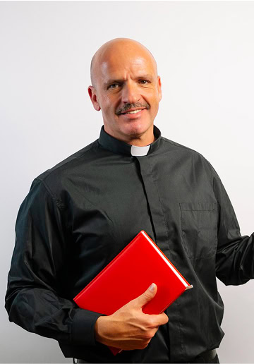 Catholic priest in black cassock holding a red book against a white background.