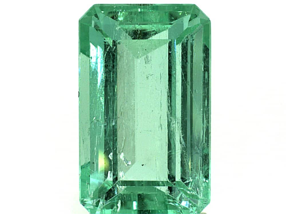 Bright green Colombian emerald cut gemstone with high clarity and brilliance.