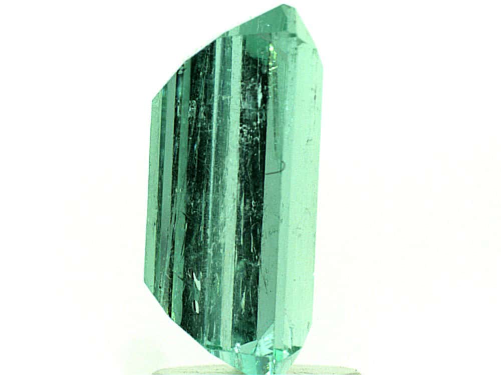 Bright green Colombian emerald cut gemstone with high clarity and vibrant color.