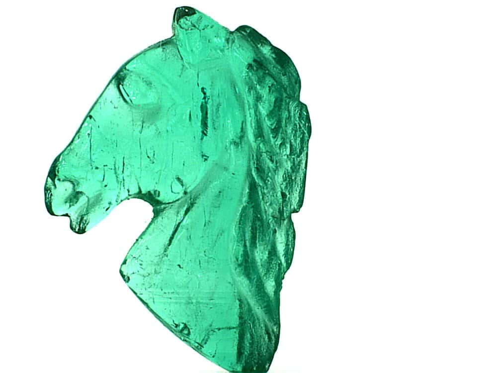 Green Colombian Emerald carved into a horse head shape.